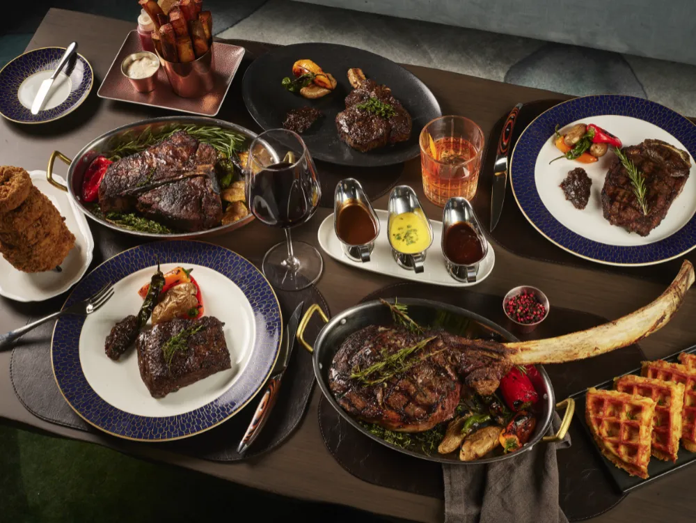 A luxurious 'From the Grill' medley platter from Crown Block, featuring various cuts of steak, lobster tails, and other fine grilled seafood.